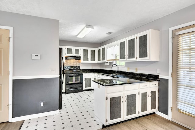 kitchen featuring white cabinetry, black appliances, and kitchen peninsula