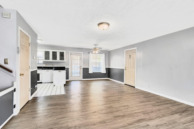 unfurnished living room with hardwood / wood-style floors, a textured ceiling, and ceiling fan