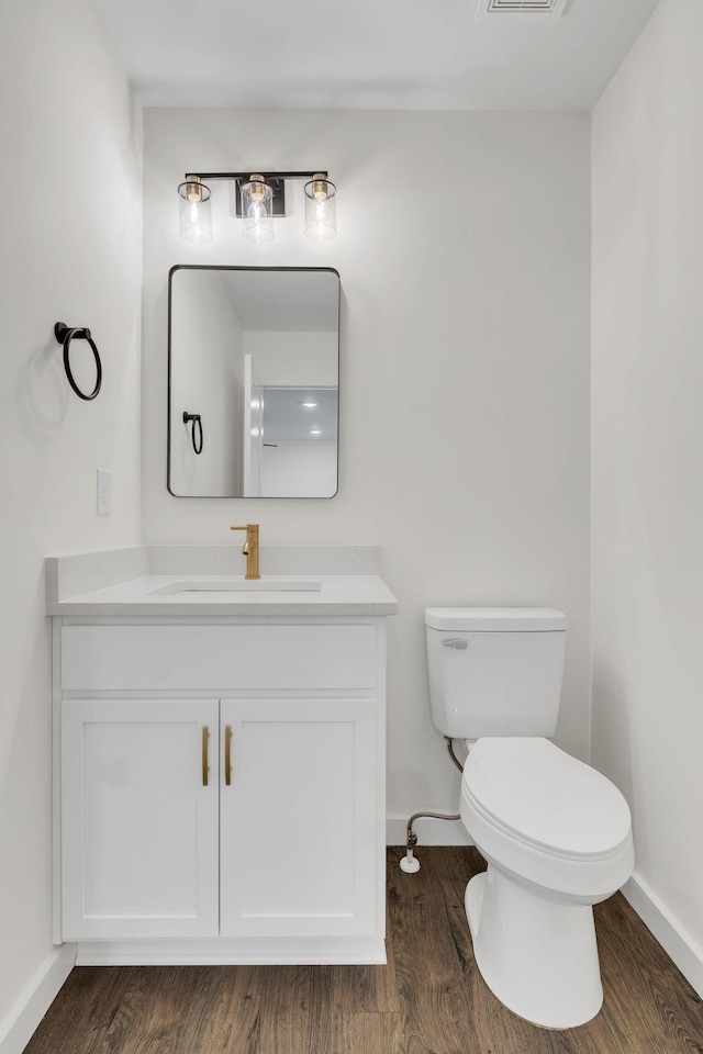 bathroom featuring vanity, hardwood / wood-style flooring, and toilet