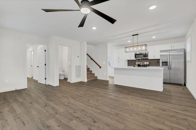 unfurnished living room with ceiling fan and dark hardwood / wood-style floors