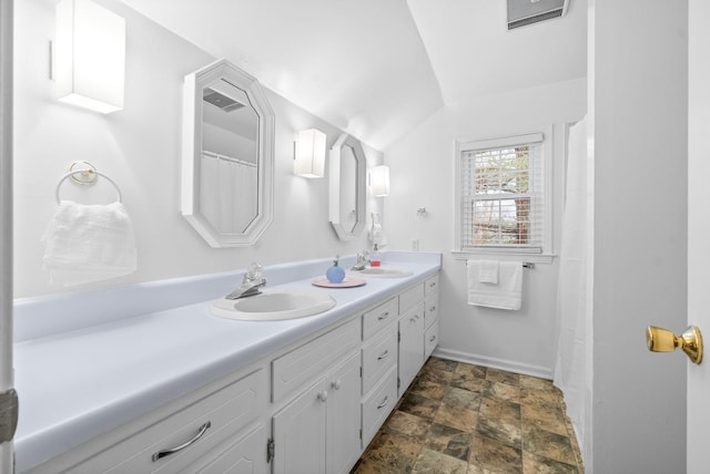 bathroom with vanity and lofted ceiling