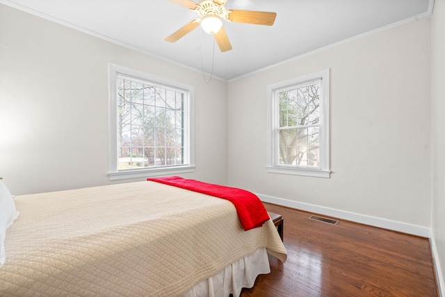 bedroom with multiple windows, crown molding, ceiling fan, and dark hardwood / wood-style flooring