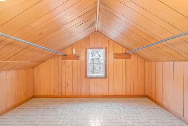 bonus room with lofted ceiling and wooden walls