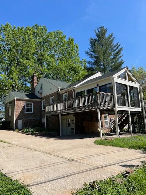115 Maplemere Dr, Clarksville, TN 37040 - view of front of property with concrete driveway, a chimney, a deck, an attached garage, and a sunroom