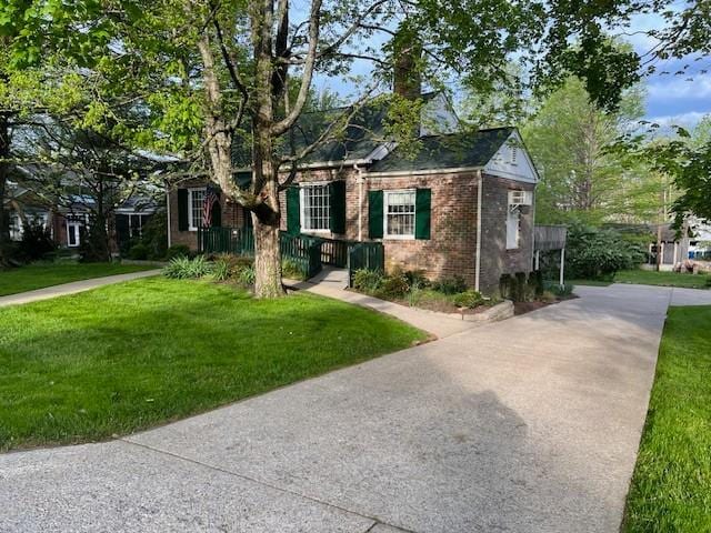 115 Maplemere Dr, Clarksville, TN 37040 - view of front of house featuring concrete driveway, brick siding, a front lawn, and a chimney