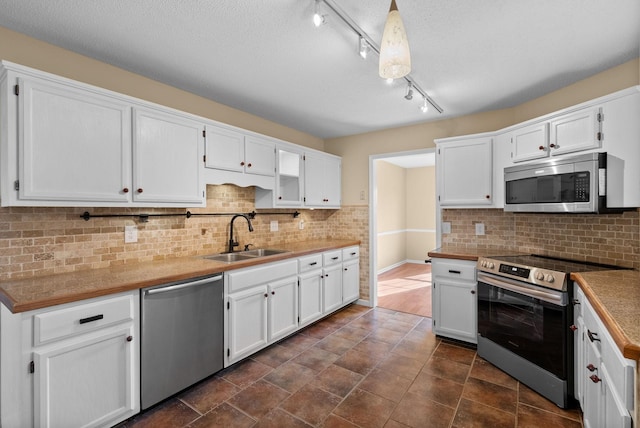 kitchen featuring stainless steel appliances, sink, and white cabinets