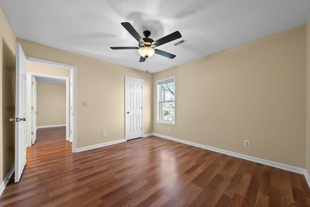 unfurnished bedroom featuring dark hardwood / wood-style flooring, ceiling fan, a closet, and a textured ceiling