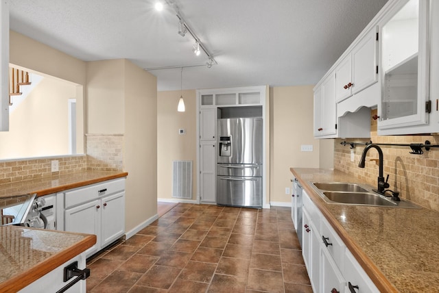 kitchen featuring sink, decorative light fixtures, appliances with stainless steel finishes, white cabinets, and backsplash