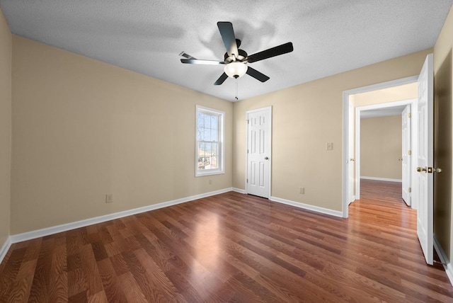 unfurnished bedroom with a closet, dark hardwood / wood-style floors, a textured ceiling, and ceiling fan