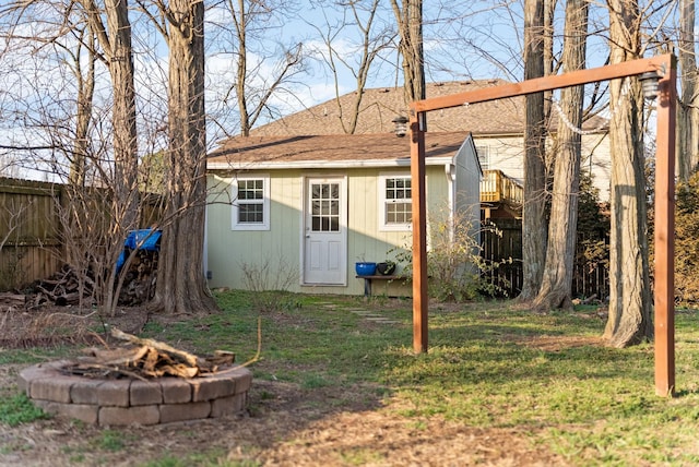 view of outbuilding featuring a fire pit and a lawn