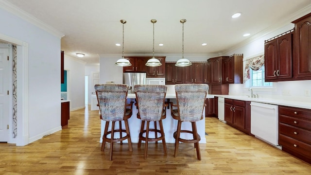 kitchen featuring white dishwasher, light wood-type flooring, a kitchen island, light countertops, and ornamental molding