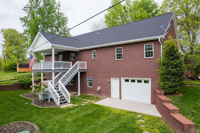 rear view of property with a garage, a yard, stairs, brick siding, and a deck