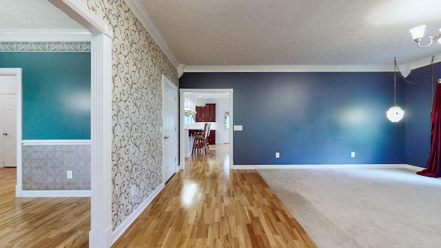 interior space with ornamental molding, wood finished floors, and baseboards