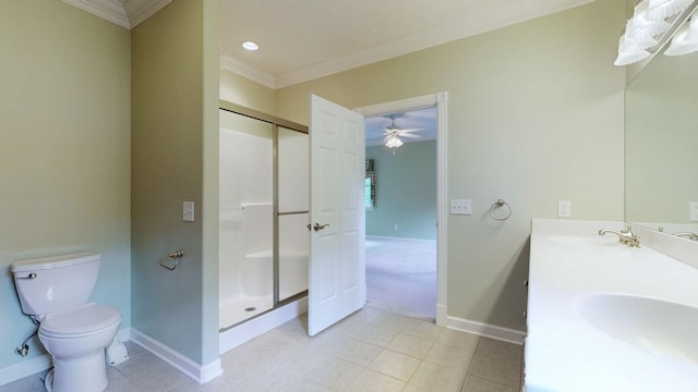 bathroom with a shower stall, toilet, a sink, baseboards, and crown molding