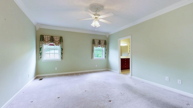 empty room with ornamental molding, ceiling fan, light carpet, and baseboards