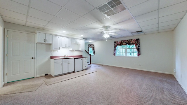 kitchen featuring white cabinets, a sink, light colored carpet, ceiling fan, and white dishwasher