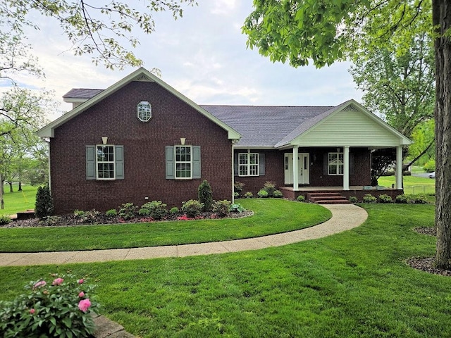 view of front of home featuring a porch, a front lawn, roof with shingles, and brick siding