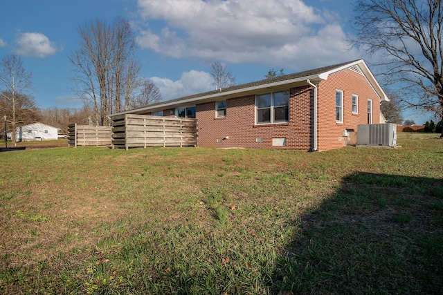 rear view of property with a yard and cooling unit