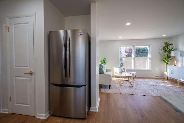 kitchen with stainless steel fridge and light hardwood / wood-style floors