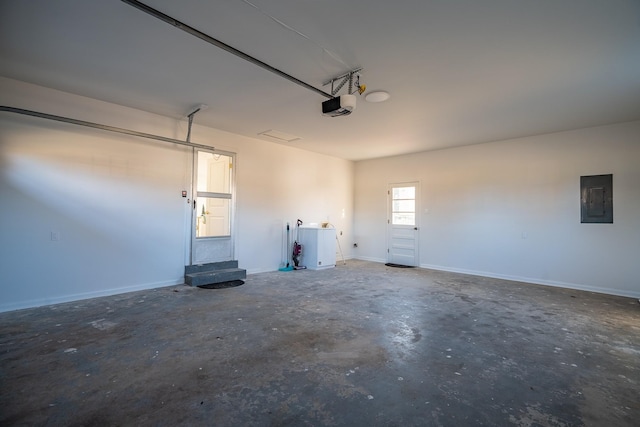 garage with a garage door opener and electric panel