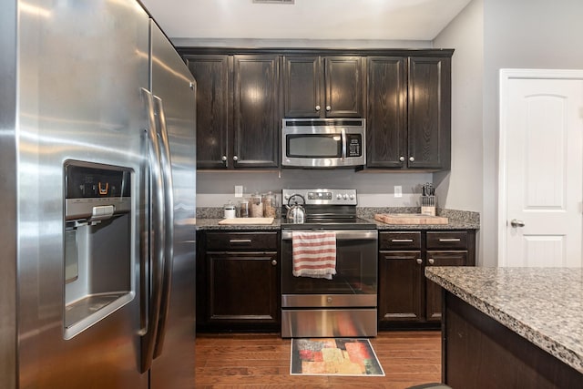 kitchen featuring appliances with stainless steel finishes, dark wood-type flooring, and dark brown cabinetry