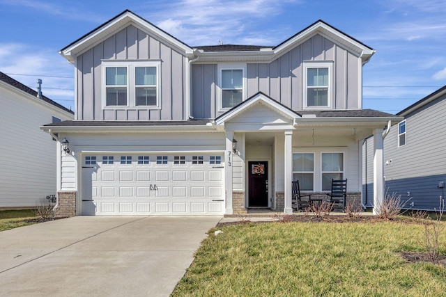 view of front of house with a garage, a front lawn, and covered porch