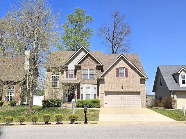 view of front of house featuring a front lawn, driveway, fence, brick siding, and an attached garage