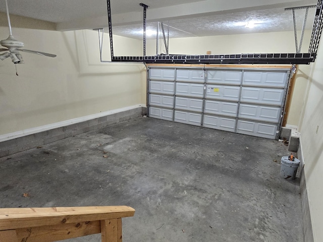 garage featuring baseboards and ceiling fan