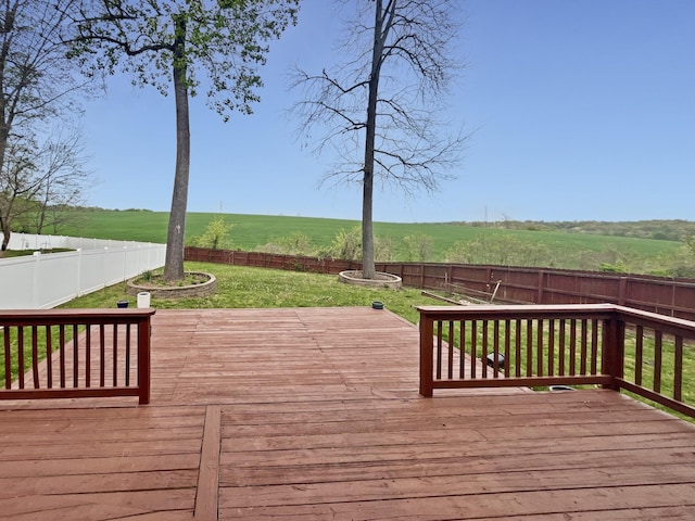 wooden terrace featuring a fenced backyard, a yard, and a rural view