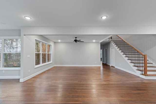 unfurnished living room with dark wood-type flooring and ceiling fan