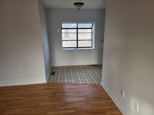 empty room with baseboards and wood finished floors