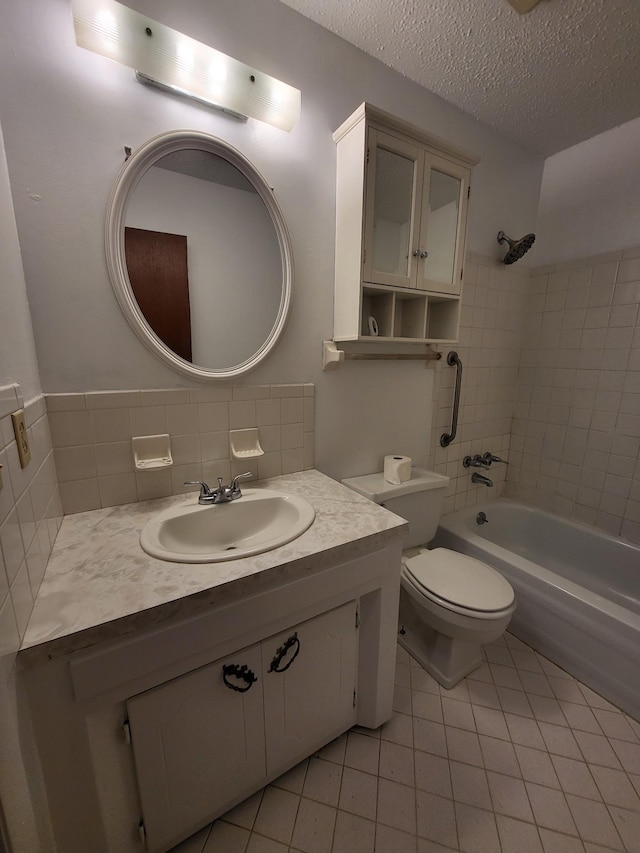 bathroom with vanity, toilet, tile patterned floors, a textured ceiling, and shower / bathing tub combination