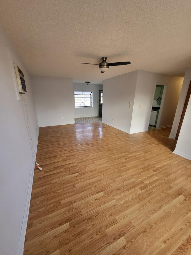 empty room with light wood-style flooring, a textured ceiling, and ceiling fan