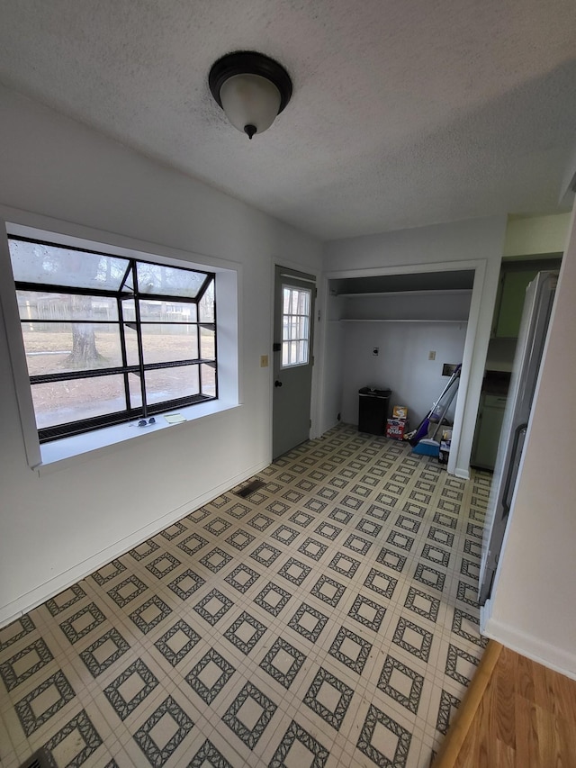 entryway with baseboards and a textured ceiling