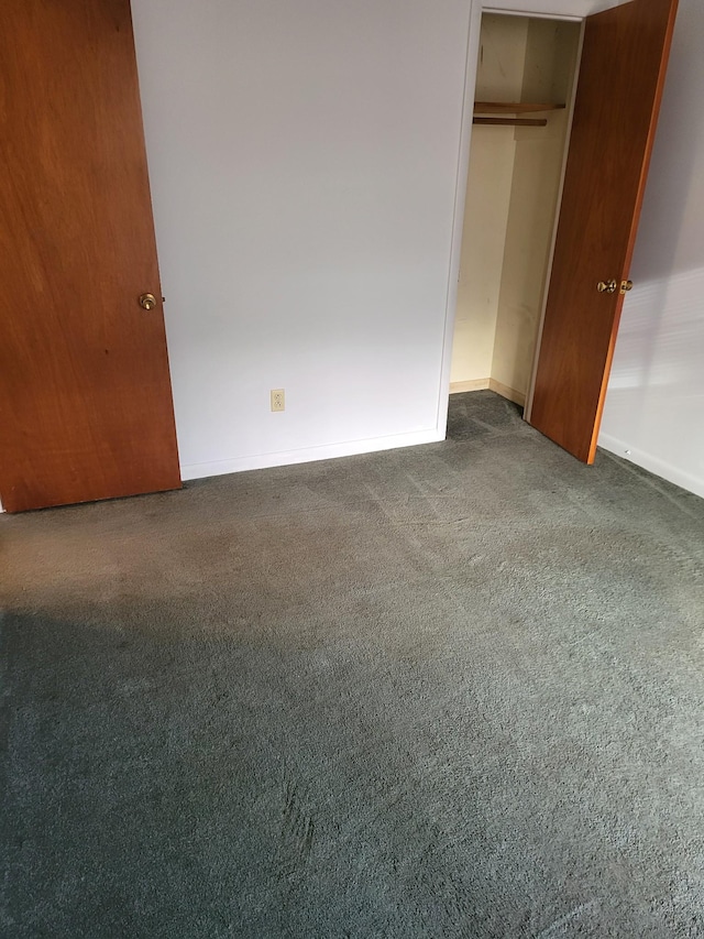 unfurnished bedroom with carpet floors, baseboards, and a closet
