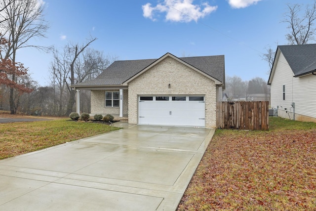 view of front of property featuring a garage, a front yard, and cooling unit