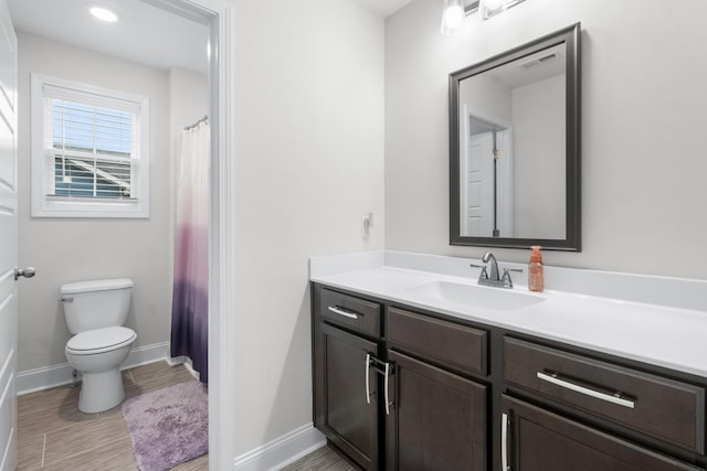 bathroom with hardwood / wood-style flooring, vanity, and toilet