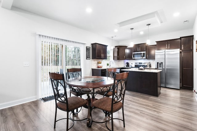 dining space featuring sink and light hardwood / wood-style flooring