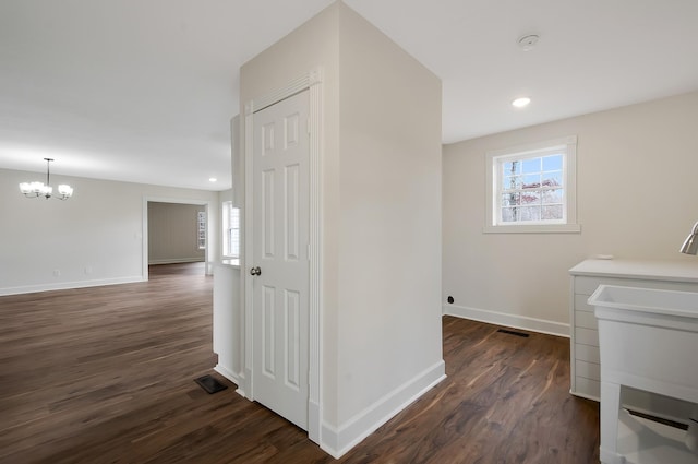 interior space featuring dark hardwood / wood-style flooring, a wealth of natural light, and an inviting chandelier