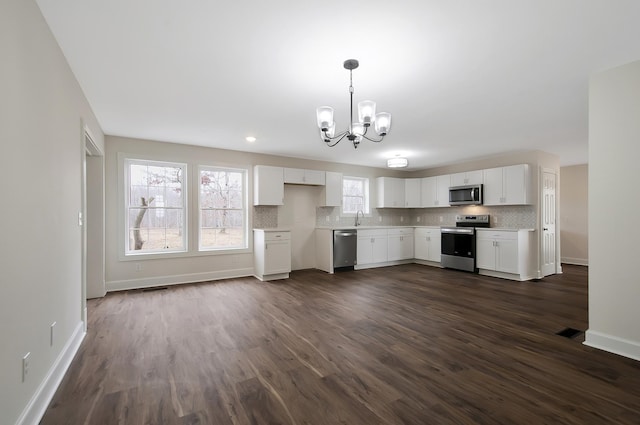 kitchen featuring backsplash, stainless steel appliances, and white cabinets