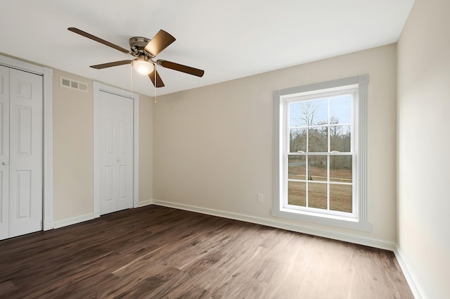 unfurnished bedroom featuring ceiling fan and dark hardwood / wood-style flooring