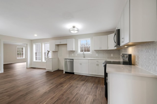 kitchen featuring dark wood-type flooring, sink, white cabinetry, appliances with stainless steel finishes, and backsplash