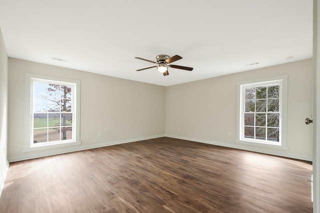 spare room with dark hardwood / wood-style flooring and ceiling fan