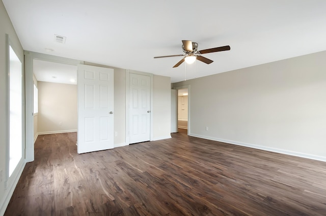 unfurnished bedroom with dark hardwood / wood-style flooring, a closet, and ceiling fan