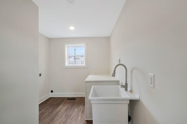 clothes washing area featuring wood-type flooring, sink, and electric dryer hookup