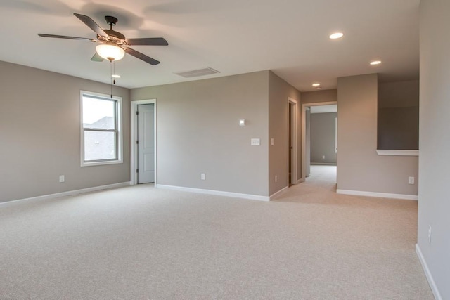 empty room featuring ceiling fan and light colored carpet