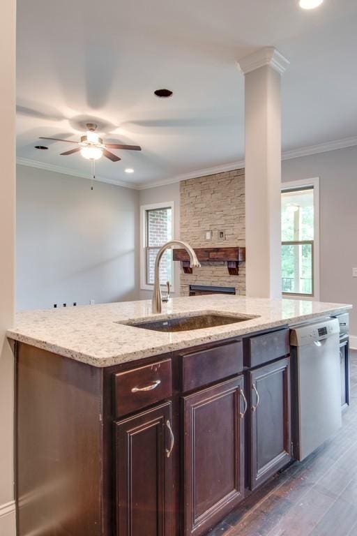 kitchen with crown molding, dishwasher, sink, and light stone countertops