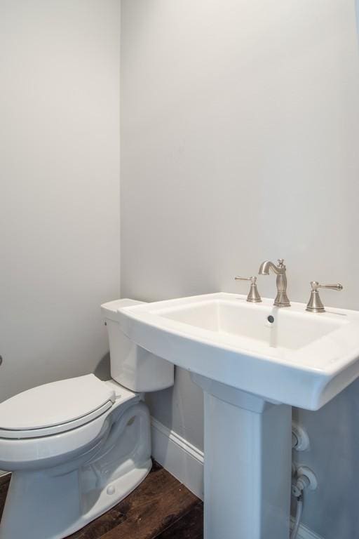 bathroom with wood-type flooring, toilet, and sink