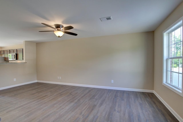 empty room with ceiling fan and dark hardwood / wood-style floors