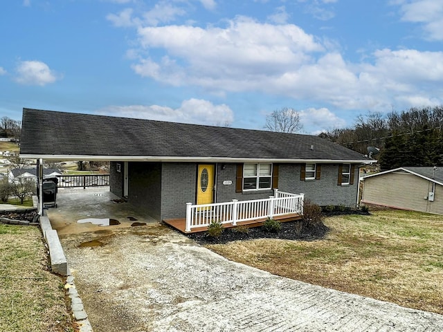 ranch-style home with a front yard, a carport, and covered porch